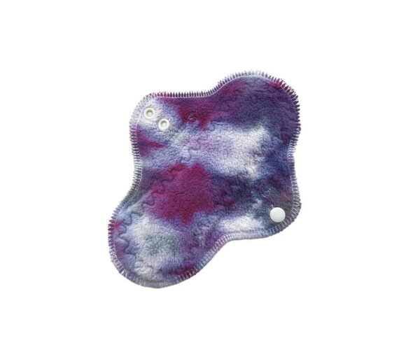 A washable cloth menstrual pad with purple galaxy hand-dyed organic cotton sherpa top and organic merino wool backing.