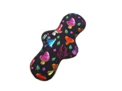 Pictured is a Roundatious shaped reusable cloth menstrual pad. It has brigt colourful mushroom organic cotton jersey print.