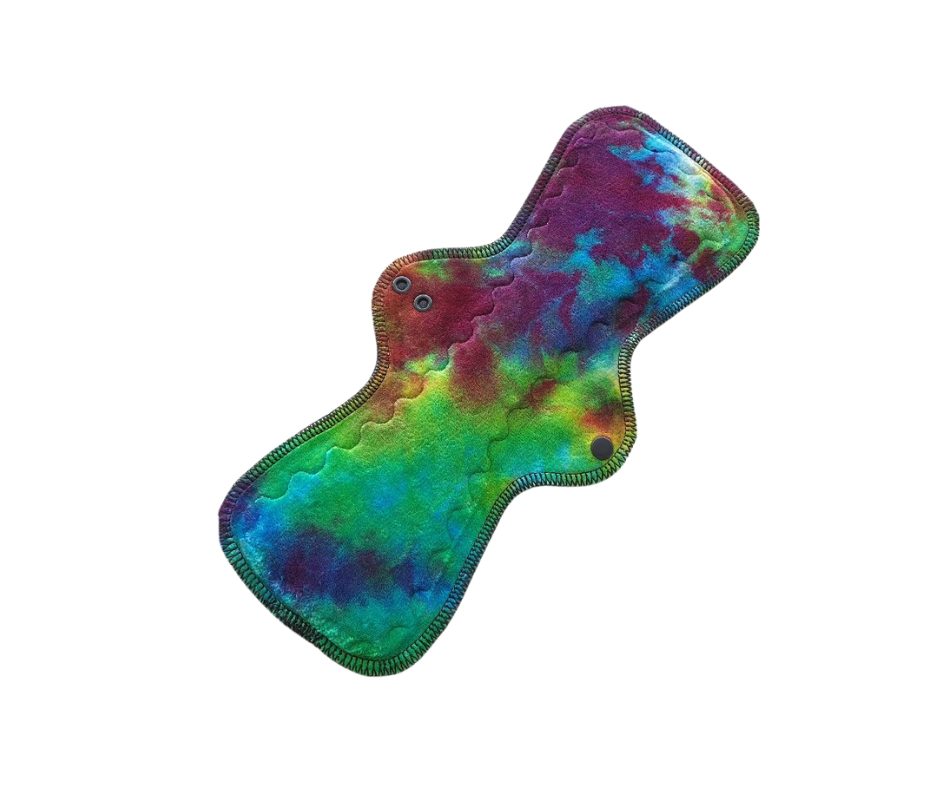 Pictured is an Angelato shape reusable cloth pad with hand-dyed organic bamboo velour viscose in a Rainbow Swirl colourway.